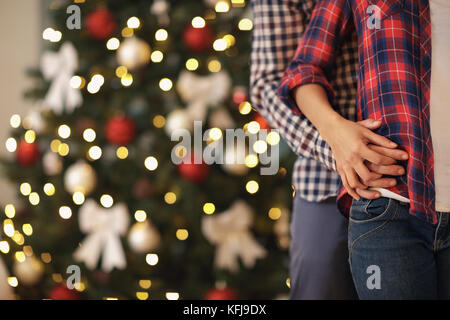 Clasped hands of young couple in love for Christmas, concept