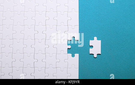 White details of a puzzle on green background. A puzzle is a puz Stock Photo