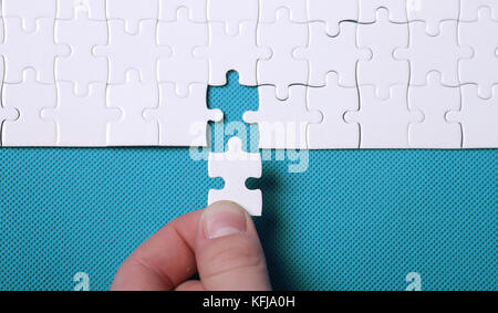 White details of a puzzle on green background. A puzzle is a puz Stock Photo