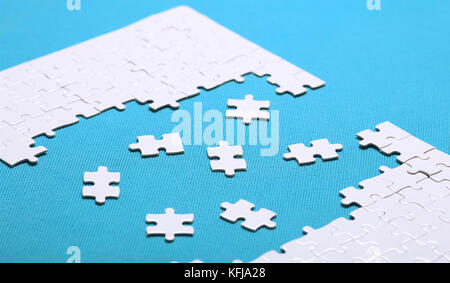White details of a puzzle on green background. A puzzle is a puz Stock Photo
