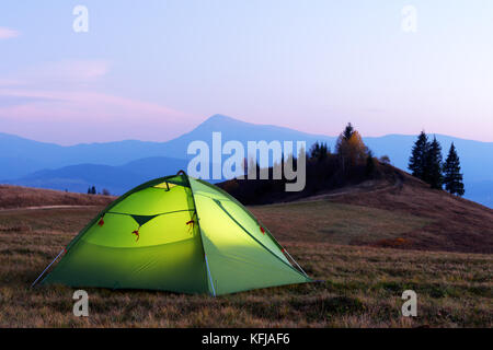 Green tent lighted from the inside Stock Photo