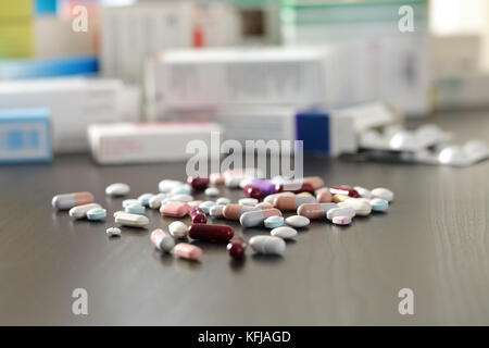 Close up of a lot of pills and medicines on a black wooden table Stock Photo
