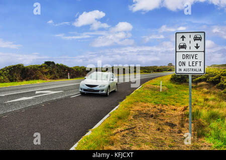 Drive on left in Australia roadside sign on Great Ocean road in VIctoria state next to regional rural speedway with lots of overseas tourist traffic. Stock Photo