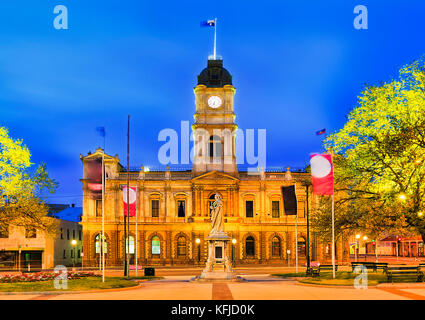 Facade of historic Town hall building in regional centre in Victoria state - Ballarat. Brightly illuminated at sunrise with Queen Victoria statue in f Stock Photo