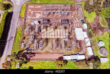 Distributing high voltage power substation in regional Australian town viewed from above on a block of land made of insulators, poles, wires and trans Stock Photo