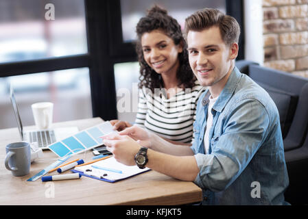 Inspired girl and boy sitting at the table and working Stock Photo