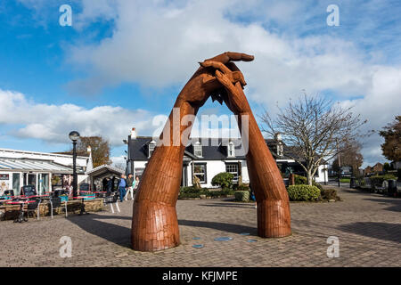 Sculpture of clasping hands in front of New Shop at the Blacksmiths restaurant in Gretna Green Gretna Dumfries & Galloway Scotland UK Stock Photo