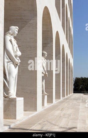 Classical statues surround the Palazzo della Civilta Italiana, known as the white marble square colosseum (Colesseo Quadrato).  EUR, Rome, Italy. Stock Photo
