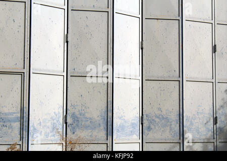 Old and damaged metal gray folding door on an abandoned warehouse ... Old and damaged metal gray folding door on an abandoned warehouse ...