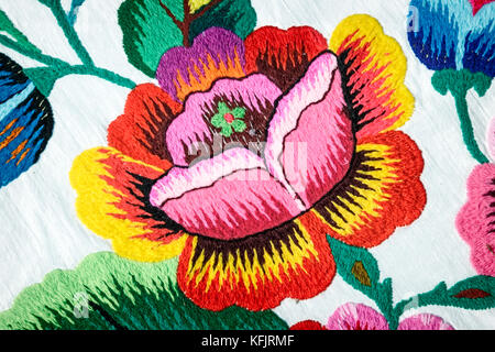 Crafts: beautiful red and yellow flower embroidered satin. Stock Photo