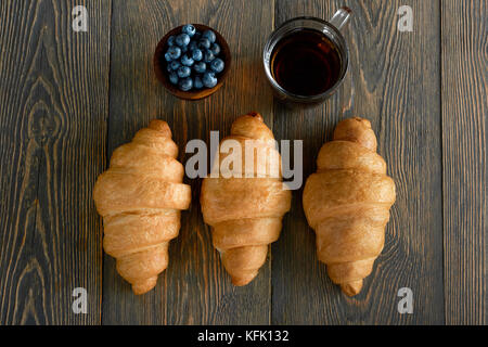 Freshly baked croissants on wooden table Stock Photo