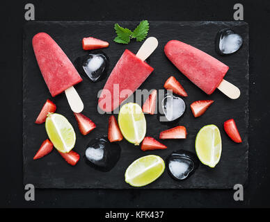 Strawberry and lime ice-creams or popsicles with fresh cut berries Stock Photo