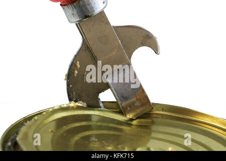 old rusty metal knife opens a metal tin can on white isolated background Stock Photo