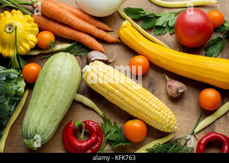 Raw organic vegetables with fresh ingredients for healthily cooking on wooden background, top view, banner. Vegan or diet food concept. Stock Photo