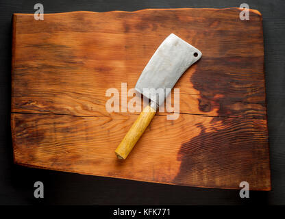 Butcher. Vintage butcher meat cleavers on dark wooden kitchen board background. Stock Photo