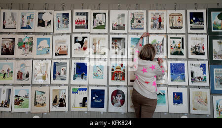 Auctioneer Catherine Southon holds examples from the Smilby cartoon collection, including works that appeared in Playboy, as she sets up her sale room in Farleigh, Surrey, ahead of their auction on the 1st of November. Stock Photo