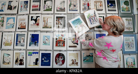 Auctioneer Catherine Southon holds examples from the Smilby cartoon collection, including works that appeared in Playboy, as she sets up her sale room in Farleigh, Surrey, ahead of their auction on the 1st of November. Stock Photo