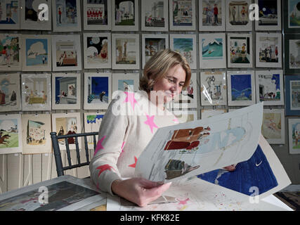 Auctioneer Catherine Southon holds examples from the Smilby cartoon collection, including works that appeared in Playboy, as she sets up her sale room in Farleigh, Surrey, ahead of their auction on the 1st of November. Stock Photo