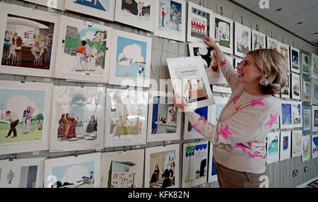 Auctioneer Catherine Southon holds examples from the Smilby cartoon collection, including works that appeared in Playboy, as she sets up her sale room in Farleigh, Surrey, ahead of their auction on the 1st of November. Stock Photo