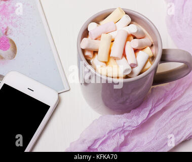 Mug coffee, cocoa with marshmallows and a phone on a white background Stock Photo