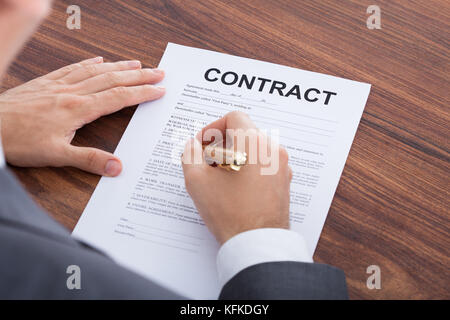 Cropped image of businessman signing contract at table Stock Photo