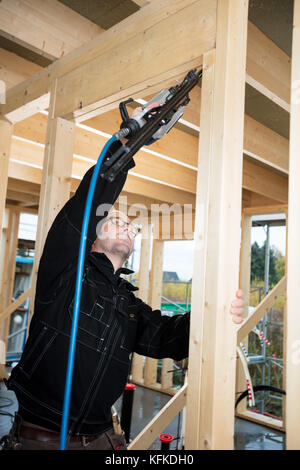 Carpenter Drilling Corner Of Wood At Site Stock Photo