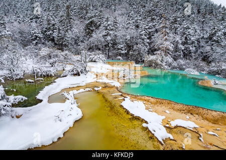 View of colorful icy lake and snow covered trees in Huanglong, Sichuan, China Stock Photo
