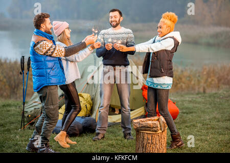 Friends in sweaters celebrating at the camping Stock Photo