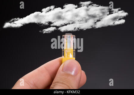 Cropped image of hand connecting network cable to cloud against black background Stock Photo