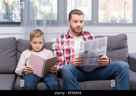 father and son reading at home Stock Photo