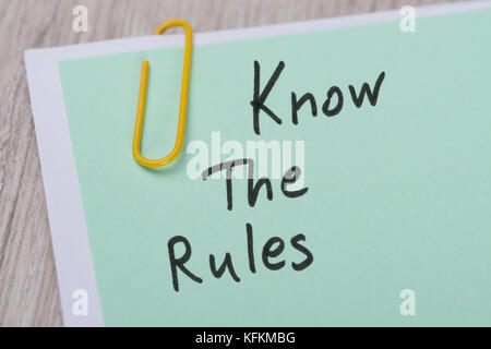 Closeup of Know The Rules ! written on green paper note with paperclip Stock Photo