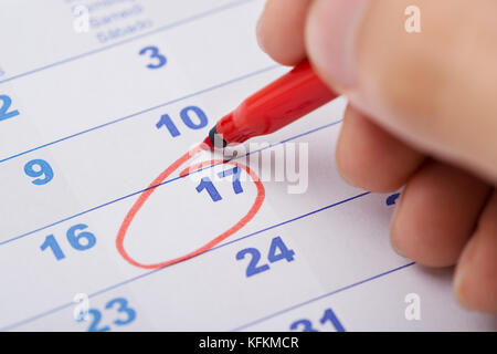 Cropped image of hand marking 17th date on calendar Stock Photo