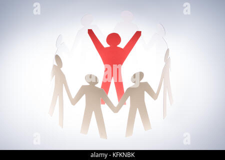 Successful red paperman surrounded by team representing unity isolated over gray background Stock Photo