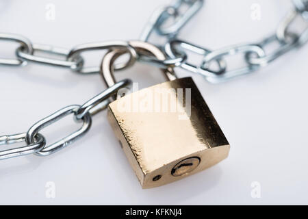 Closeup of metallic padlock and chains against white background Stock Photo