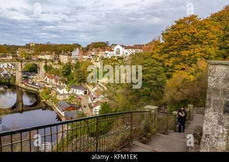 Couple admiring an autumn view of Knaresborough, North Yorkshire. View over the River Nidd towards the town's railway viaduct and riverside. UK, 30th October, 2017. Stock Photo