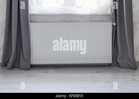Part of a bright room with heating convector radiator installed under the window. Stock Photo