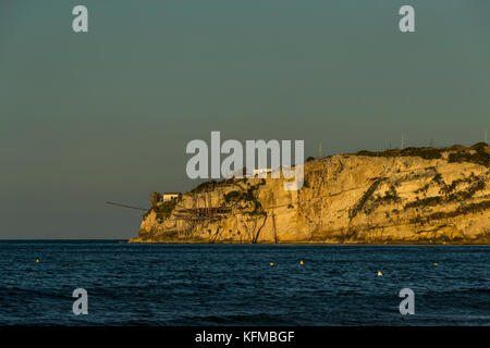 The rocky headlands of Peschici, Italy dotted with traditional fishing towers called trabucco, Gargano National Park, Puglia. Stock Photo