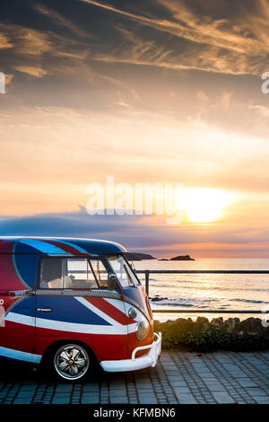 A vintage Volkswagen Camper van painted in the colours of the Union Flag parked at Little Fistral in Newquay Cornwall. Stock Photo