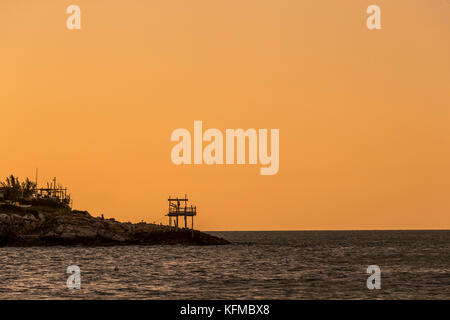 The rocky headlands of Peschici, Italy dotted with traditional fishing towers called trabucco, Gargano National Park, Puglia. Stock Photo