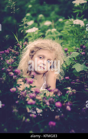 little blond girl with pink clover flowers Stock Photo