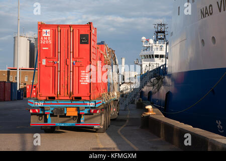 Mini containers wait on a flatbed lorry to be loaded onto offshore supply ship at Asco supply base in Great Yarmouth. Stock Photo