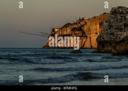 The rocky headlands of Peschici, Italy dotted with traditional fishing towers called trabucco, Gargano National Park, Puglia. Stock Photo