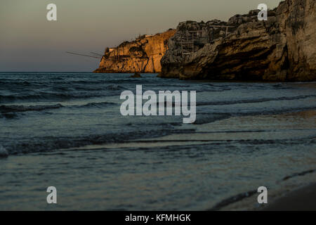 The rocky headlands of Peschici, Italy dotted with traditional fishing towers called trabucco, Gargano National Park, Puglia. Stock Photo