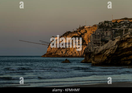 The rocky headlands of Peschici, Italy dotted with traditional fishing towers called trabucco, Gargano National Park, Puglia. Stock Photo