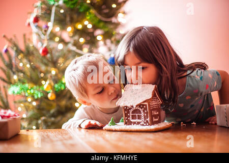 Kids with gingerbread house Stock Photo