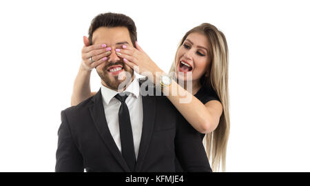 Woman makes surprise for her boyfriend. Girlfriend is covering the man's eyes. Fashionable clothes. Stock Photo