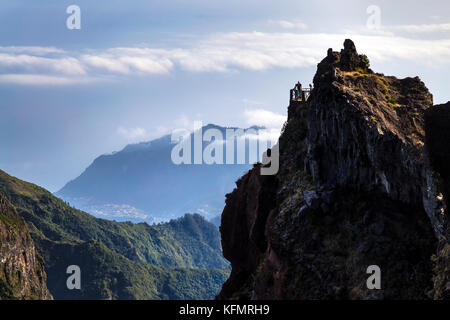 People looking over stunning scenery of mountains along the hiking trail between Pico do Arieiro and Pico Ruivo, Madeira, Portugal Stock Photo