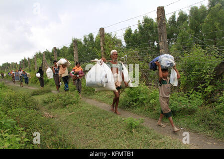 Myanmar: Rohingya refugees fleeing military operation in Myanmar’s Rakhine state, walk along the Myanmar-Bangladesh border fence near Maungdaw to take shelter into Bangladesh on September 7, 2017. Over half a million Rohingya refugees from Myanmar’s Rakhine state, have crosses into Bangladesh since August 25, 2017 according to UN. The Myanmar military's latest campaign against the Rohingyas began after the attack on multiple police posts in Rakhine state. © Rehman Asad/Alamy Stock Photo Stock Photo