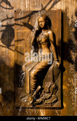 Stone carving of woman under a fountain Stock Photo