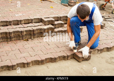 laying paving slabs on city square, repairing sidewalk Stock Photo